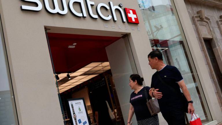 People walk past a store of Swiss watchmaker Swatch, in Beijing, China August 18, 2025. REUTERS/Tingshu Wang
