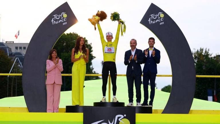 UAE Team Emirates XRG’s Tadej Pogacar celebrates on the podium wearing the yellow jersey after winning the Tour de France, as Paris’ mayor Anne Hidalgo applauds - REUTERS