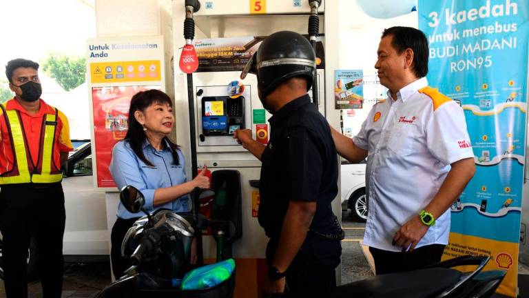 Timbalan Menteri Kewangan Lim Hui Ying (dua, kiri) menyantuni anggota polis semasa hadir menyaksikan warga Polis Diraja Malaysia (PDRM) menikmati subsidi petrol RON95 di stesen minyak Shell Jalan Masjid Negeri pada harga RM1.99 berbanding harga pasaran semasa RM2.05 seliter, menerusi inisiatif BUDI MADANI RON95 (BUDI95) yang bermula hari ini- BERNAMA