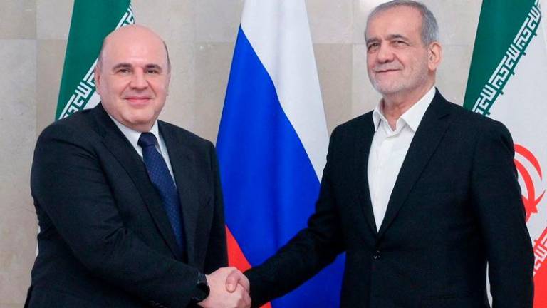 In this pool photograph distributed by the Russian state agency Sputnik, Russia's Prime Minister Mikhail Mishustin meets with Iran's President Masoud Pezeshkian in Moscow on January 17, 2025. (Photo by Alexander ASTAFYEV / POOL / AFP)