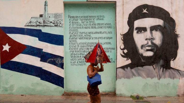 A woman walks on the street as Hurricane Rafael passes by Havana - REUTERSpix