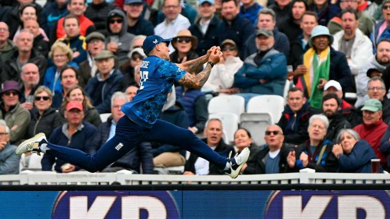 England’s Brydon Carse jumps but fails to make the catch for the wicket of West Indies’ Sherfane Rutherford (unseen) during the third One Day International (ODI) cricket match between England and West Indies at The Oval in London on June 3, 2025. (Photo by Glyn KIRK / AFP)