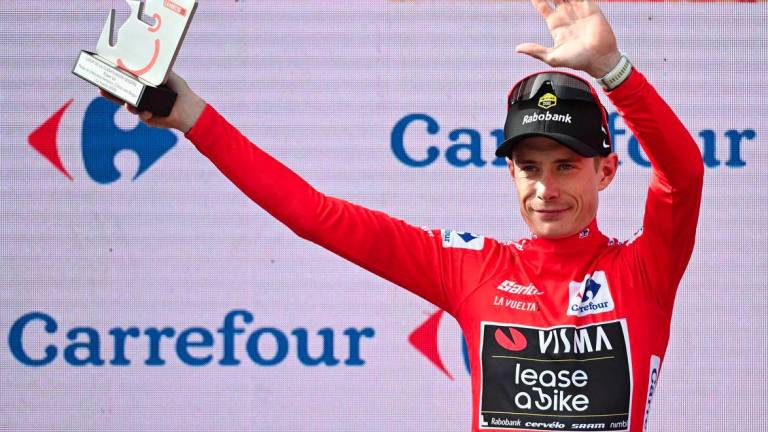 The overall leader Team Visma-Lease a bike's Danish rider Jonas Vingegaard celebrates on the podium wearing the red jersey after the tenth stage of the Vuelta a Espana cycling tour, a 168 km race between Sendaviva Natural Park in Arguedas and El Ferial Larra Belagua in Isaba, on September 2, 2025. - AFPPIX