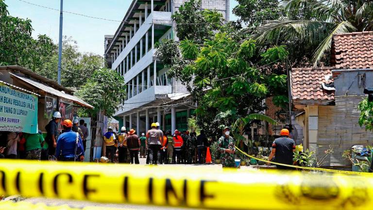 Pasukan penyelamat berkumpul berhampiran lokasi runtuhan bangunan pada Isnin, di mana masih terdapat mangsa yang terperangkap menurut agensi mitigasi bencana, ketika operasi mencari dan menyelamat diteruskan di sekolah pondok Al Khoziny, Sidoarjo, wilayah Jawa Timur, Indonesia, 2 Oktober 2025. REUTERSpis