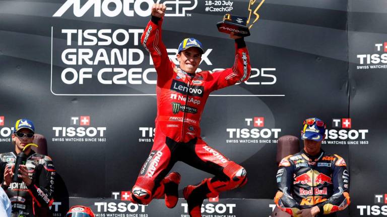 Ducati Lenovo Team’s Marc Marquez celebrates with a trophy on the podium after winning the MotoGP race REUTERS/David W Cerny TPX IMAGES OF THE DAY