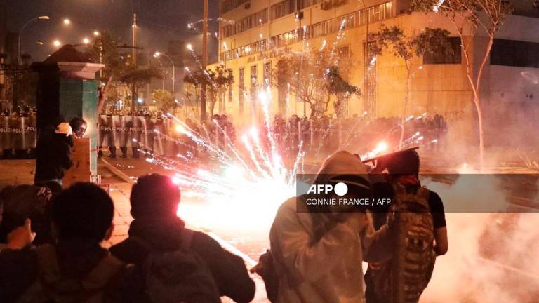 Demonstrators clash with anti-riot police officers during protest against Peru's interim President Jose Jeri in Lima on October 15, 2025. - CONNIE FRANCE / AFP