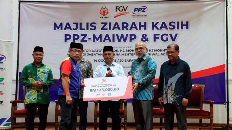 Minister in the Prime Minister’s Department (Religious Affairs) Senator Datuk Dr Mohd Na’im Mokhtar looks on as FGV Holdings Berhad Chairman Tan Sri Rastam Isa (second from right) presents a mock cheque for FGV Holdings Berhad’s wakalah contribution to the Chairman of the PPR Taman Wahyu 2 Residents’ Association, Abdullah Uda Saidi, at the PPZ-MAIWP &amp; FGV Ziarah Kasih event at the Taman Wahyu 2 Community Hall today. – BERNAMA