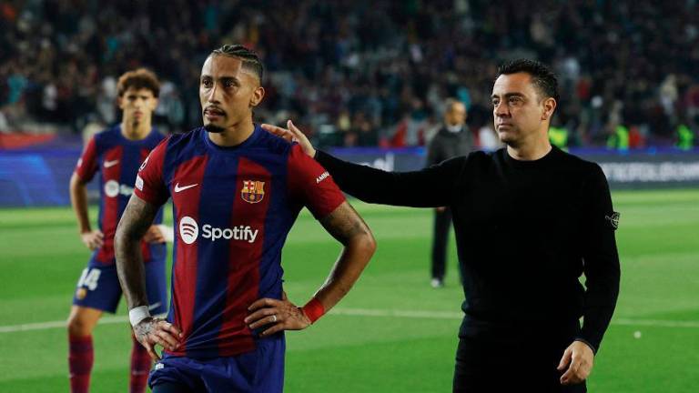 Barcelona’s Raphinha (left) and coach Xavi look dejected after the match. – REUTERSPIX