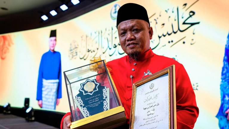 Penerima Anugerah Tokoh Pendakwah, Wan Masindra Juja bersama sijil dan piala pada sambutan Maulidur Rasul 1447H/2025M peringkat negeri Perak di sebuah hotel malam ini. - BERNAMA