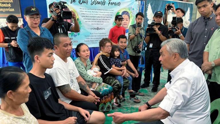 Timbalan Perdana Menteri Datuk Seri Dr Ahmad Zahid Hamidi ketika menyantuni keluarga mangsa tanah di Kampung Mook, Kinarut di sini, yang mengorbankan Emily Johnny, 38, dan anaknya Xarell Myre Aristothle, 11, dalam kejadian pada Isnin lepas. - BERNAMA