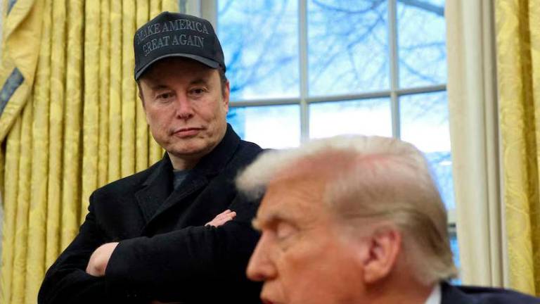 Elon Musk listens to U.S. President Donald Trump speak in the Oval Office of the White House - REUTERSpix