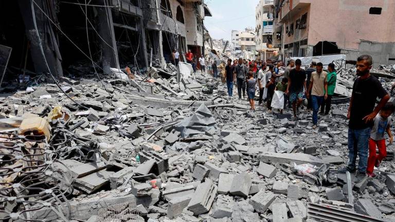 Palestinians inspect the site of a morning Israeli strike on a house, in Gaza City, August 8, 2025. Mahmoud Issa/ REUTERS