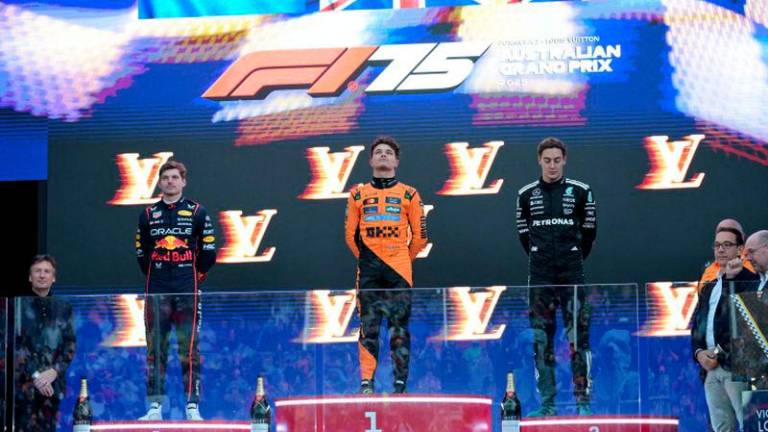 Formula One F1 - Australian Grand Prix - Albert Park Grand Prix Circuit, Melbourne, Australia - March 16, 2025McLaren's Lando Norris on the podium after winning the Australian Grand Prix along with second placed Red Bull's Max Verstappen and third placed Mercedes' George Russell - REUTERSPIX