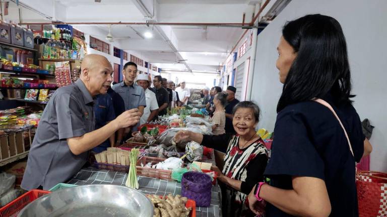 Menteri Perdagangan Dalam Negeri dan Kos Sara Hidup, Datuk Armizan Ali, berinteraksi mesra dengan peniaga di Pasar Am Papar ketika melakukan walkabout di Pekan Papar, hari ini. - fotoBERNAMA