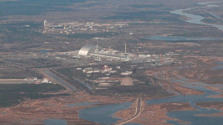 An aerial view from a plane shows a New Safe Confinement (NSC) structure over the old sarcophagus covering the damaged fourth reactor at the Chernobyl Nuclear Power Plant. - REUTERS/Gleb Garanich/File Photo