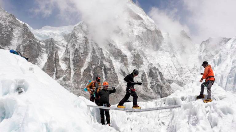 Mountaineers practice walking on a ladder during a training session at Everest base camp, Nepal April 15, 2025. - REUTERS