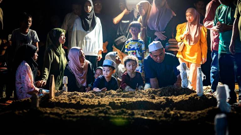 Waris mangsa kemalangan membabitkan dua kenderaan di Kilometer 7, Jalan Jerantut-Maran, Pahang, semalam, hadir pada pengebumian jenazah keluarga masing-masing di Tanah Perkuburan Islam Kampung Selat, Bota Kanan, awal pagi ini. - Bernama