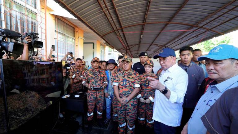 Prime Minister Datuk Seri Anwar Ibrahim during a site visit to the landslide location at Country Heights, Penampang, today. Also present was Sabah Chief Minister Datuk Seri Hajiji Noor (right). – BERNAMA