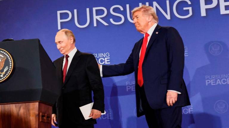 U.S. President Donald Trump holds Russian President Vladimir Putin during a press conference following their meeting to negotiate an end to the war in Ukraine, at Joint Base Elmendorf-Richardson, in Anchorage, Alaska, U.S., August 15, 2025. - REUTERS