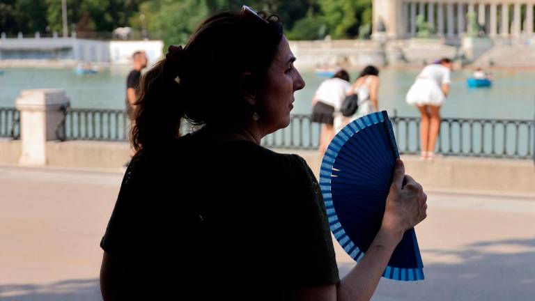 A woman uses a hand fan in a park during the first heatwave of the summer in Madrid, on June 28, 2025. Starting June 28, 2025 southern Europe will once again face extreme temperatures exceeding 40°C. - AFPpix