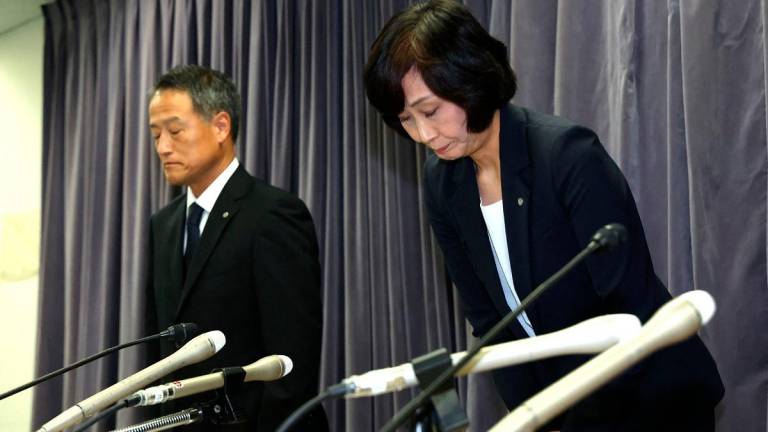 Japan Airlines President Mitsuko Tottori (R) apologizes at a press conference after receiving a letter of severe warning from the Ministry of Land, Infrastructure, Transport and Tourism, regarding a pilot’s drinking scandal, in Tokyo on September 10, 2025. - JIJI PRESS / AFP