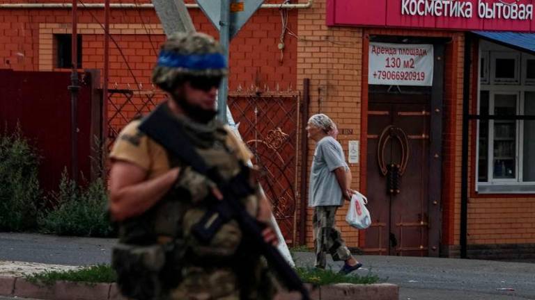 A Ukrainian serviceman patrols an area in the controlled by Ukrainian army town of Sudzha, Kursk region - REUTERSpix