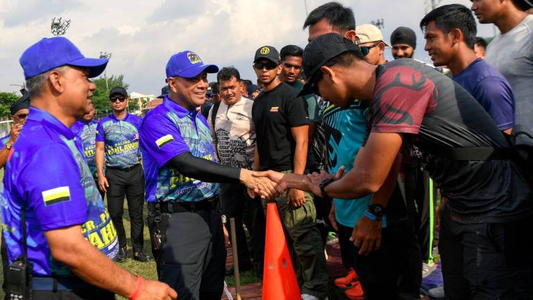 Ketua Polis Perak Datuk Noor Hisam Nordin (tengah) menyantuni anggota polis yang juga peserta ketika hadir pada perasmian Program Ter...Paling Pahlawan Challenge 2025 di Padang Speedy hari ini. Turut bersama Ketua Polis Daerah Hilir Perak ACP Dr Bakri Zainal Abidin (kiri) - fotoBERNAMA