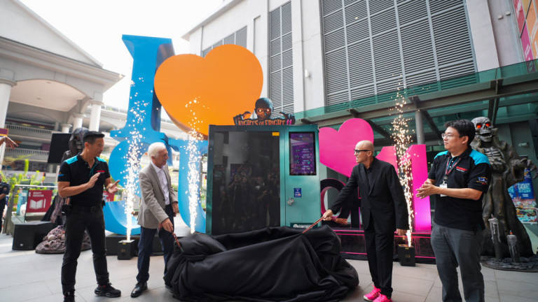 Professor Sibrandes Poppema, President of Sunway University, and Mr. Lynton V. Harris, Founder and Chief Executive Officer of The Sudden Impact Entertainment Company, lead the dramatic reveal of the NOF 11 vending machine, flanked by partners and key guests.