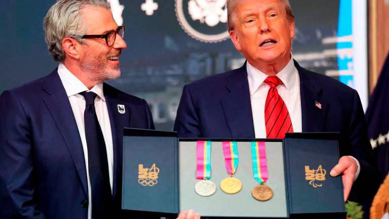 U.S. President Donald Trump, accompanied by LA28 Chairman Casey Wasserman, holds 1984 Los Angeles Olympics medals as he delivers remarks before signing an executive order to create a White House Olympics task force to handle security and other issues related to the LA 2028 Summer Olympics, in the South Court Auditorium on the White House campus in Washington. Reuterspix