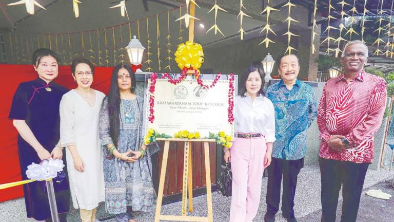 Tan, his wife Esther (third, right) and GuruMatha (third, left) at the opening of the soup kitchen. – Adib Rawi Yahya/THESUN