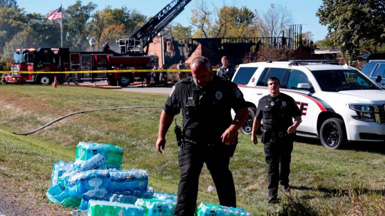 Law enforcement officers work near the burnt Church of Jesus Christ of Latter-day Saints, after a shooting and a fire took place, in Grand Blanc, Michigan, U.S., September 28, 2025. REUTERS/Rebecca Cook TPX IMAGES OF THE DAY