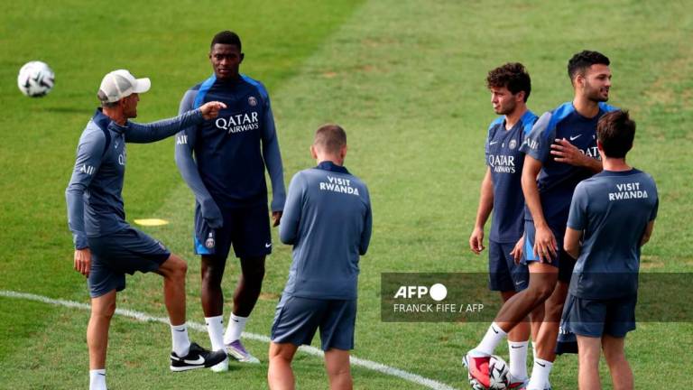 Paris Saint-Germain's Spanish headcoach Luis Enrique (L) speaks with Paris Saint-Germain's Portuguese defender #25 Nuno Mendes (2ndL) during a training session at French L1 Paris Saint-Germain (PSG) football club's training ground at Poissy, north-west of Paris on August 21, 2025, on the eve of the L1 football match PSG against SCO Angers. - AFPPIX