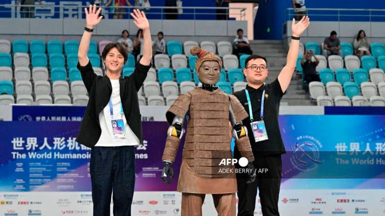 Winner of the dance event from Beijing Dance Academy and Hubei Optics Valley Dongzhi celebrates during the award ceremony at the World Humanoid Robot Games in Beijing on August 15, 2025. - AFP