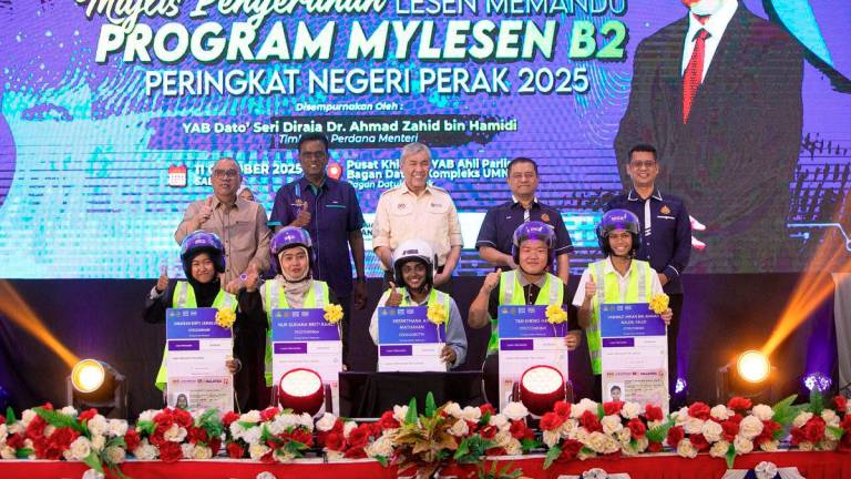 Timbalan Perdana Menteri Datuk Seri Dr Ahmad Zahid Hamidi (belakang,tiga,kiri) bergambar bersama penerima pada Majlis Penyerahan Lesen Memandu Program MyLesen B2 Peringkat Negeri Perak Tahun 2025 di Kompleks Umno Bagan Datuk di sini hari ini. Turut sama Ketua Setiausaha Kementerian Pengangkutan Malaysia Datuk Seri Jana Santhiran Muniayan (belakang,dua,kiri) Pengerusi Jawatankuasa Pembangunan Luar Bandar, Perladangan, Pertanian dan Industri Makanan negeri, Datuk Mohd Zolkafly Harun (belakang,kiri) dan Ketua Pengarah Jabatan Pengangkutan Jalan (JPJ) Datuk Aedy Fadly Ramli (belakang,empat,kiri). - BERNAMA