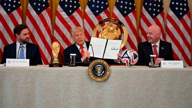 US President Donald Trump holds up a document creating the “White House Task Force on the FIFA World Cup 2026” as US Vice President JD Vance (L) and FIFA president (Fédération Internationale de Football Association) Gianni Infantino look on in the East Room of the White house in Washington, DC, on May 6, 2025. AFPpix