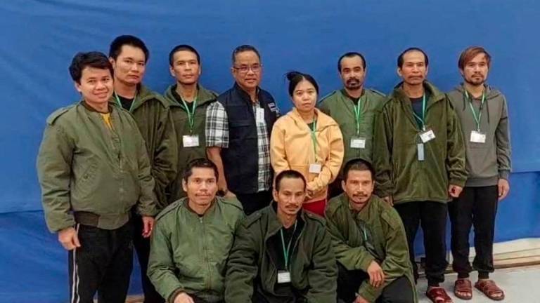 Thai workers taken hostage by Hamas and later released as part of a deal between Israel and Palestinian Islamist group Hamas, pose with a member of Thai mission after a medical checkup, in Tel Aviv, Israel - REUTERSPIX