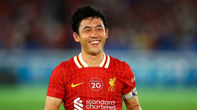 Liverpool’s Wataru Endo is presented with an award after the match - REUTERS