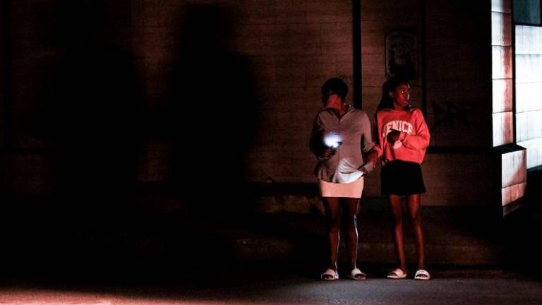 Cubans stand on a corner during a general blackout in Havana on March 14, 2025. Cuba suffered another general blackout on March 14, 2025, caused by a failure in its national electricity system, the Ministry of Energy and Mines reported. - AFPPIX