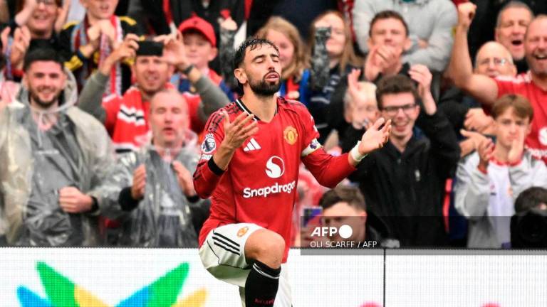 Manchester United's Portuguese midfielder #08 Bruno Fernandes celebrates scoring their third goal from the penalty spot during the English Premier League football match between Manchester United and Burnley at Old Trafford in Manchester, north west England, on August 30, 2025. - AFP