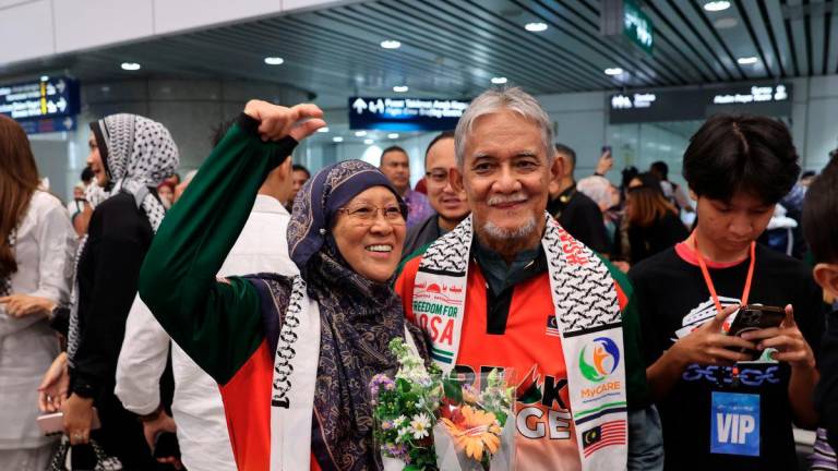 The married couple, who are also two Malaysian volunteers participating in the Freedom Flotilla Coalition (FCC) and Thousand Medleens to Gaza (TMTG) humanitarian mission, Dr Fauziah Hassan (left) and Prof Emeritus Dr Mohd Alauddin Mohd Ali (centre), upon their arrival at Kuala Lumpur International Airport (KLIA) Terminal 1 today. - BERNAMA