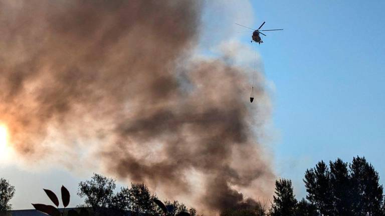 A fire-fighting helicopter collects water to control a fire after a Russian missile and drone strike, amid Russia’s attack on Ukraine, in Kyiv, Ukraine August 28, 2025. REUTERS/Stringer