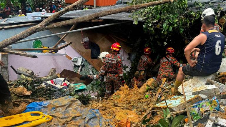 Rescue personnel searching for individuals trapped beneath the rubble of a collapsed house at Kampung Cenderakasih in Kota Kinabalu. – PIC COURTESY OF SABAH FIRE AND RESCUE DEPARTMENT