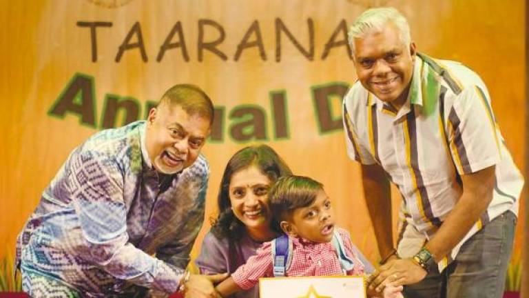 Vijay (left), Umayal (second from left) with a parent, and child accepting an award.