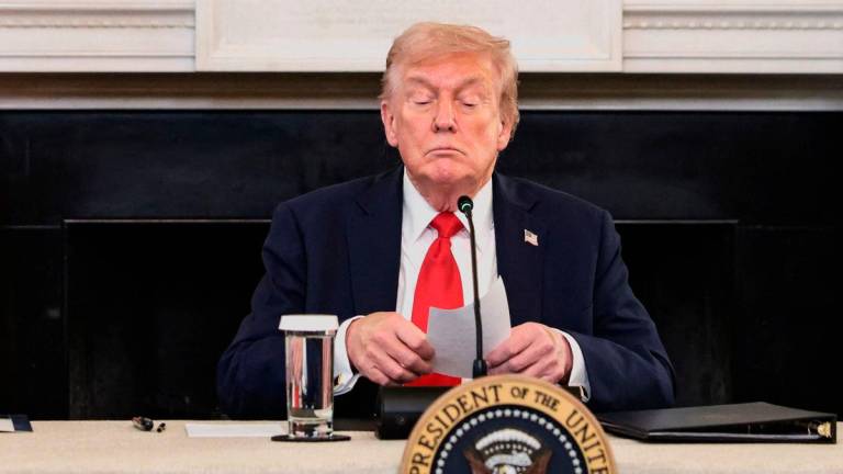 U.S. President Donald Trump holds a note that was handed to him by U.S. Secretary of State Marco Rubio during a roundtable on antifa, an anti-fascist movement Trump designated a domestic “terrorist organization” via executive order on September 22, at the White House in Washington, D.C., U.S., October 8, 2025. REUTERS/Evelyn Hockstein TPX IMAGES OF THE DAY