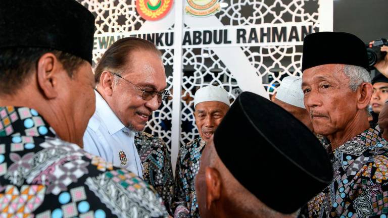 Perdana Menteri Datuk Seri Anwar Ibrahim beramah mesra bersama rakan-rakannya ketika hadir pada Majlis Perasmian Penutupan Program MADANI Rakyat (PMR) 2025 Kedah di Kompleks Sukan Majlis Daerah Baling hari ini. - BERNAMA