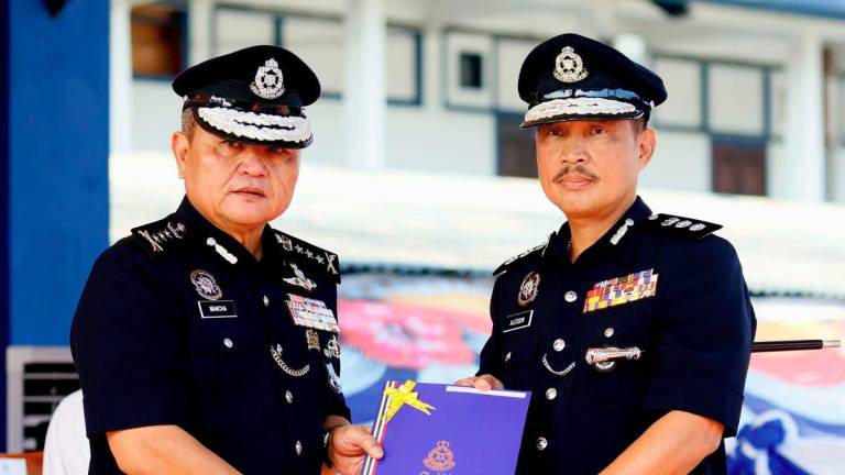 Sarawak Police Commissioner Datuk Mancha Ata presents a certificate of appreciation to Kuching District Police Chief ACP Alexson Naga Chabu (right) during the Sarawak Police monthly assembly at the Parade Ground of the Sarawak Police Contingent Headquarters (IPK) today. - BERNAMA