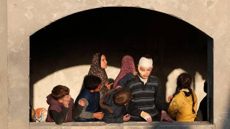 Palestinian children inspect the damage at the site of an Israeli strike on a house, amid the Israel-Hamas conflict, in Deir Al-Balah, in the central Gaza Strip - REUTERSpix