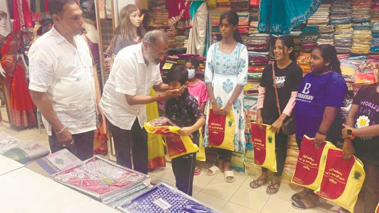 Rajendran presenting the gifts to the children during the event. – P. CHANDRA SAGARAN/THESUN