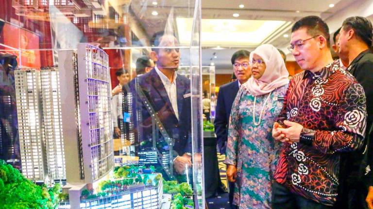 Nga views a scale model of an urban development project during the WCSC 2025 in Kuala Lumpur yesterday. Also present was KL Mayor Datuk Seri Maimunah Mohd Sharif. – ADAM AMIR HAMZAH/THESUN
