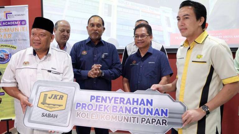 Menteri Pendidikan Tinggi Datuk Seri Zambry Abdul Kadir (tiga, kanan) bersama timbalannya Datuk Mustapha Sakmud (dua, kanan) menyaksikan acara penyerahan kunci bangunan Kolej Komuniti Papar daripada Jurutera Daerah Jabatan Kerja Raya Papar Ir. Mohamed Ibni Sabul (kanan) kepada Setiausaha Bahagian Pembangunan, Ghazali Hizam (kiri) pada majlis penyerahan Kolej Komuniti Papar di Pusat Komersil Sri Alam Perdana hari ini. - fotoBERNAMA
